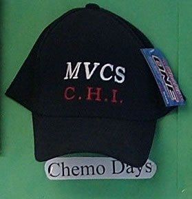 Black baseball cap embroidered MVCS in white and C.H.I. in red, photographed with a paper label reading Chemo Days.