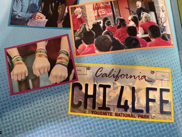 Scrapbook page with a California Yosemite National Park plate reading CHI 4LFE, students’ colored wristbands, and a gathering of students in red shirts.